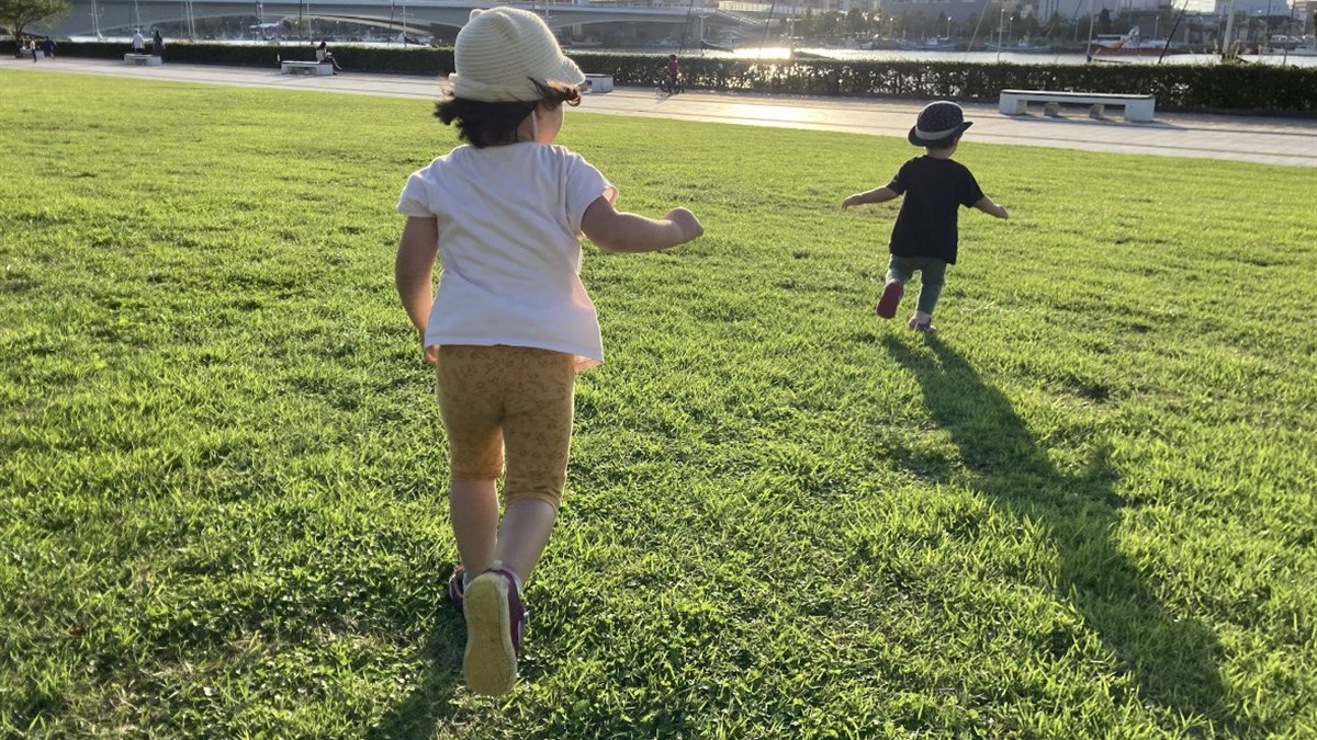 草地を駆ける子どもたち
